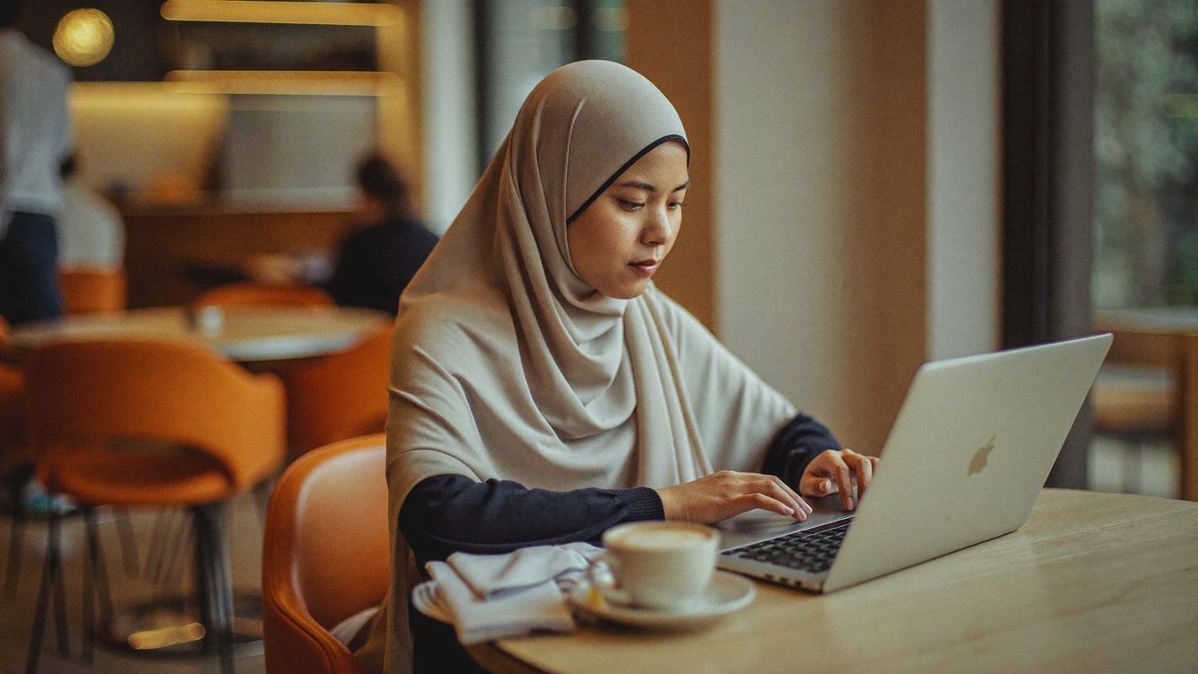 Freelancer working on a laptop in a Malaysian cafe